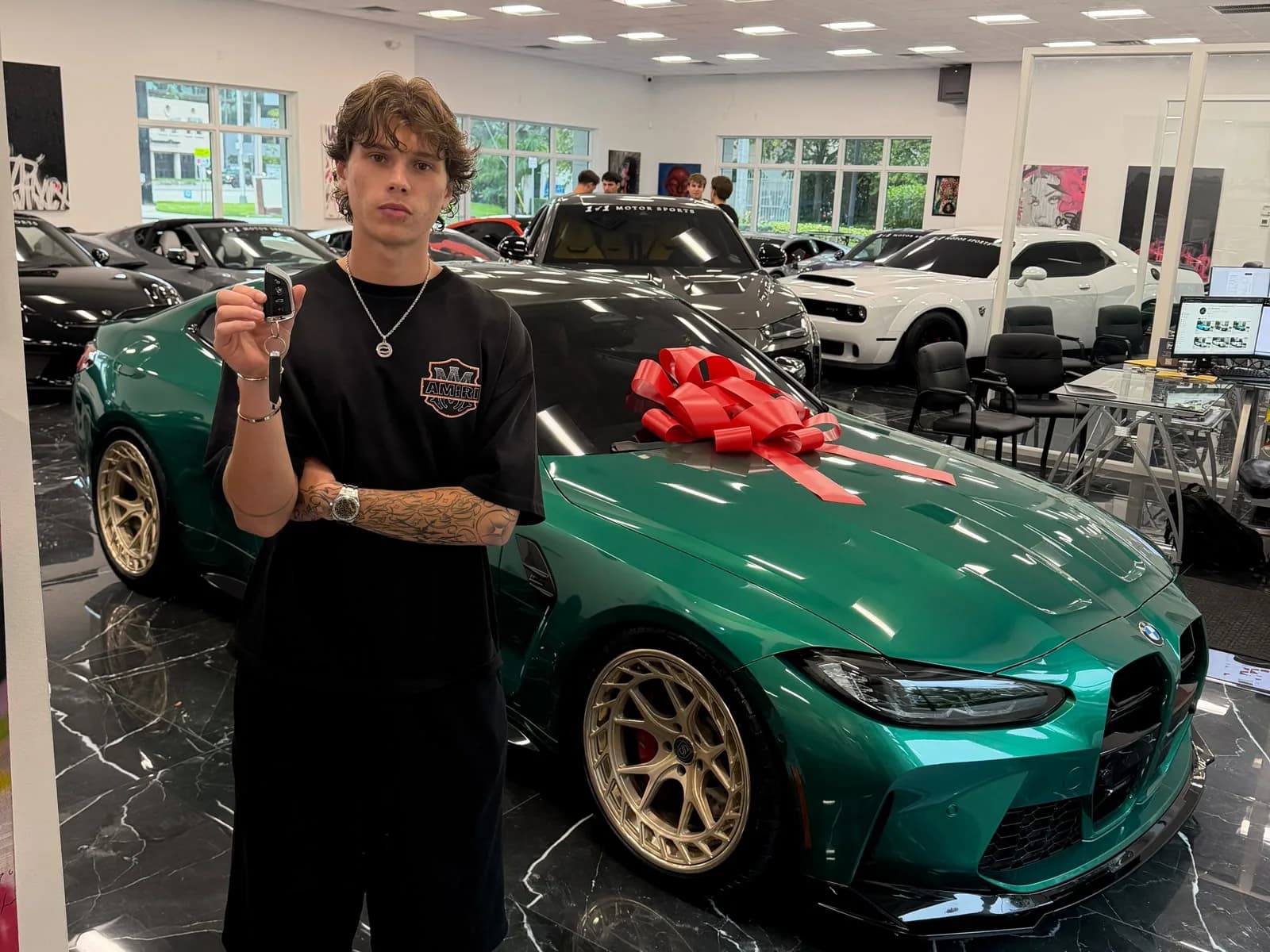 Brez holding the keys to the green BMW M4 Competition
